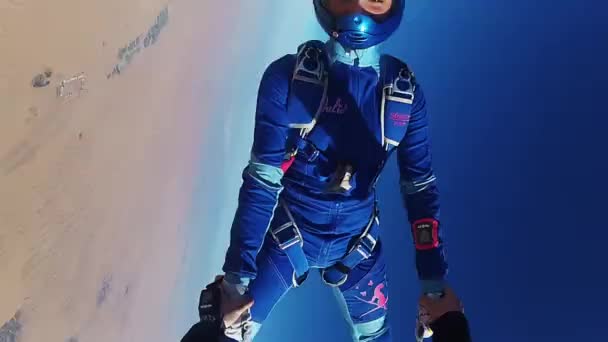 Dubai, Verenigde Arabische Emiraten - 15 februari 2014: professionele skydiver vrouw sprong van vliegtuig in blauwe hemel. Zonnige. Man van de hand te houden — Stockvideo