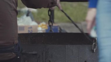 Sıcak kömür siyah metal mangal açık yanma siyah üniforma stirrs adam.