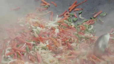 Karışık renkli sebze ve kahverengi et karıştırılır ve büyük tavada komposto.