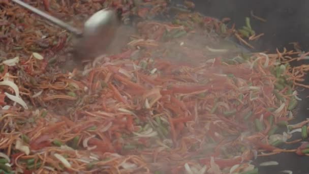 Il mix asiatico di verdure in salsa liquida viene mescolato con un mestolo nel grande wok. — Video Stock