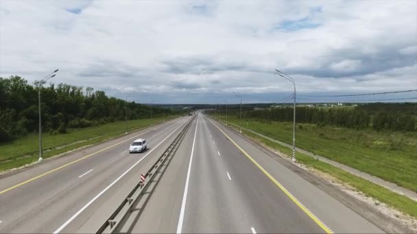 Güzel bir otomobil, kırsal alanın büyük yeşil alanları ile uzun geniş yol manzarası gökyüzü — Stok video