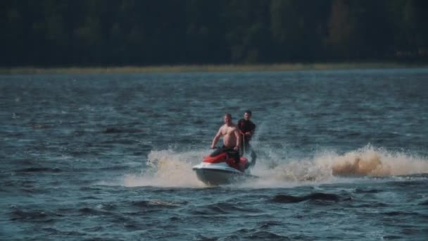 SAINT PETERSBURG, RUSSIA - AUGUST 13, 2016: Sportsman in life vest riding wakeboard on lake, holding rope tied to jet ski — Stock Video