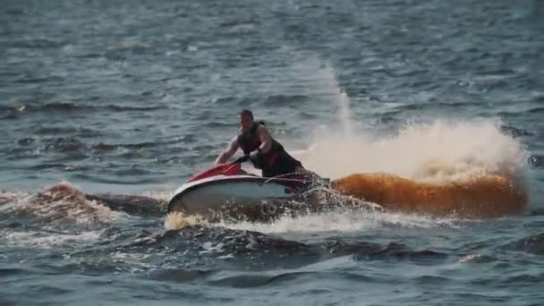 SAINT PETERSBURG, RUSSIA - AUGUST 13, 2016: Thick man in life vest riding jet ski on lake water, making turns and jumps — Stock Video