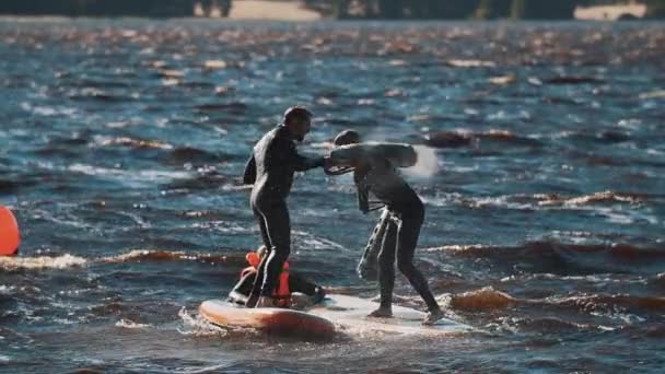 SANTO PETERSBURGO, RUSSIA - 13 AGOSTO 2016: Due uomini che combattono con morbidi pipistrelli in piedi su tavola da surf in acqua ondulata — Video Stock