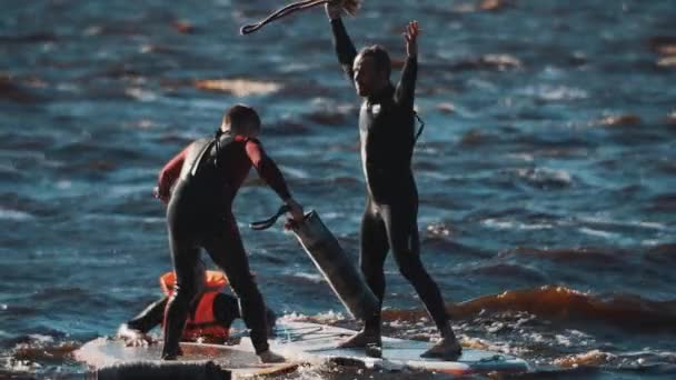 SAN PETERSBURG, RUSIA - 13 DE AGOSTO DE 2016: Dos deportistas pelean con esteras enrolladas sobre tabla de surf en agua ondulada — Vídeo de stock