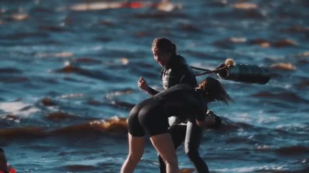 Petrohrad, Rusko - 13. srpna 2016: Dvě ženské surfaři boj s měkkou netopýry na desce surfing ve zvlněné vodě — Stock video