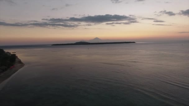 Aérea de mar con aguas tranquilas reflejando el cielo despejado al atardecer en verano . — Vídeos de Stock