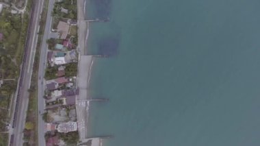 Limanı, şehir evleri, kırsal yol ve araba ile mavi su gökyüzü görünümü.