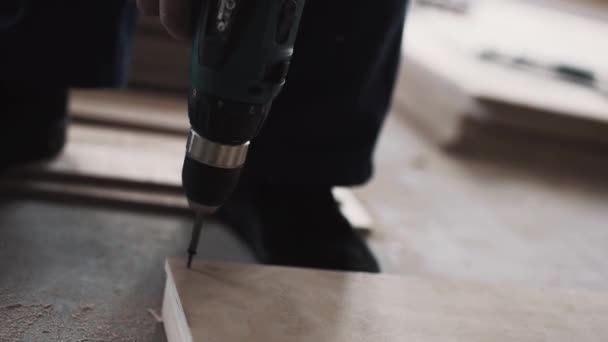 Mans manos están utilizando destornillador mecánico para atornillar tablón de madera amarillo . — Vídeos de Stock