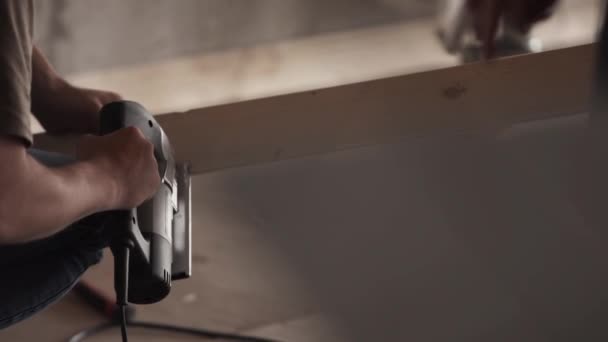 Τα χέρια τα αρσενικά χρησιμοποιούν μηχανικό εργαλείο wokk σε ξύλινη σανίδα στο πτωχοκομείο. — Αρχείο Βίντεο