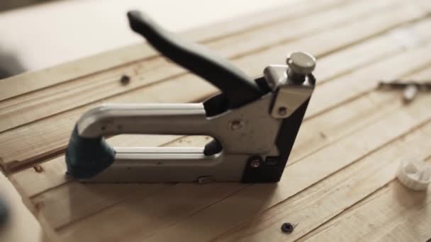Nya moderna häftpistol placeras på träbord i lager och tagit hand — Stockvideo