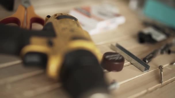 Destornillador automático amarillo, clavos, grapas, herramientas metálicas colocadas en la mesa — Vídeo de stock