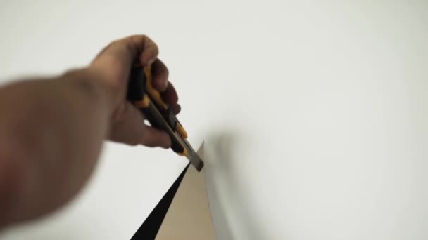 Camera toont workermans handen wit vel met geel papier mes snijden. — Stockvideo