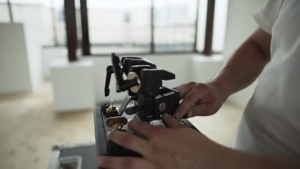 Males hands are setting different things on black plastic device in room — Stock Video