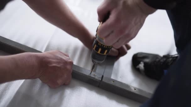 Camera shows mans hand holding and working with electric screwdriver. — Stock Video