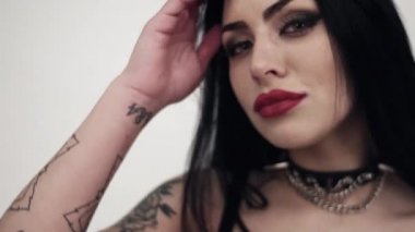Dövme ve büyük bir büstü ile siyah deri giymiş seksi esmer kız portresi.