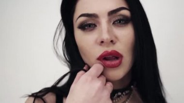 Seksi esmer dövme ve büyük bir büstü ile siyah deri giyen kadın portresi.
