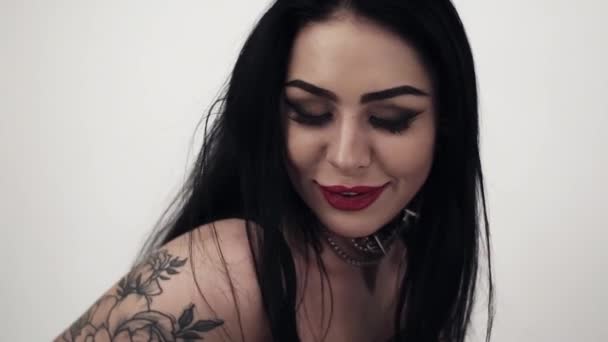 Schattige brunette vrouw leder met tatoeage op arm en agressieve make-up dragen — Stockvideo