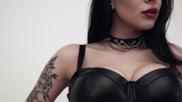 Mujer caliente que usa cuero con tatuaje grande en el brazo y maquillaje agresivo — Vídeos de Stock