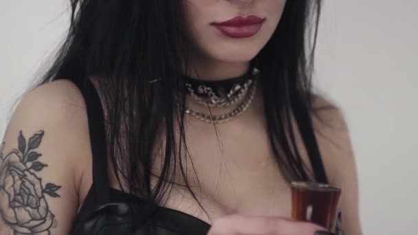 Femme avec bras tatoués, boissons à cheveux longs en verre avec liquide et citron . — Video