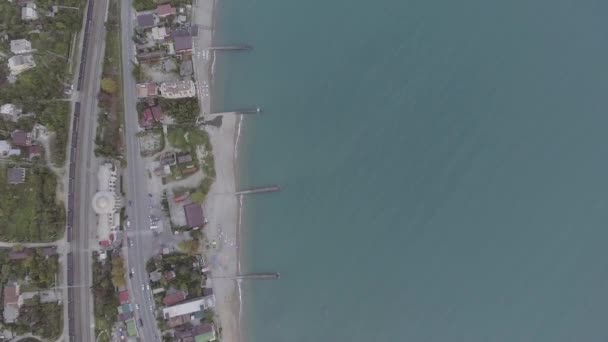 Schattig bovenaanzicht van het blauwe water met de haven, herenhuizen, landelijke weg en auto 's. — Stockvideo
