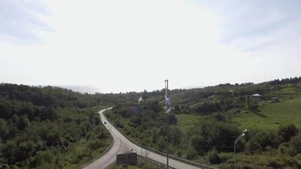 Vista da bandeira acenando de Abkhazia no vento no fundo da estrada no dia ensolarado — Vídeo de Stock