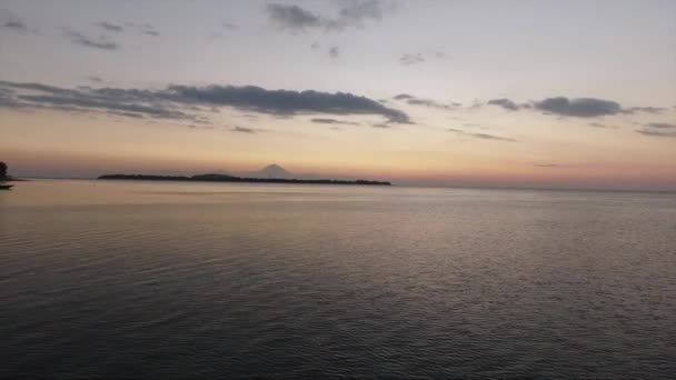 Drohnen-Ansicht des Meeres mit stillem Wasser, das den klaren Himmel bei Sonnenuntergang im Sommer reflektiert — Stockvideo
