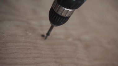Adamın ellerini sarı ahşap tahta becermek mekanik tornavida kullanarak.