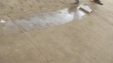 Ahşap zemin ile beyaz boya silindiri Günışığı odasında boyanıyor.