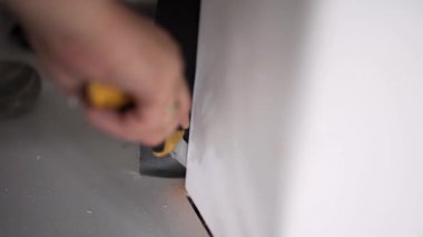 Kamera gösterir erkek işçiler ellerini beyaz çarşaf inşaat bıçak ile kesme.