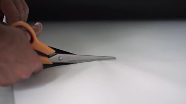 Kamera workermans elleri beyaz turuncu makasla kesme gösterir.