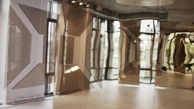 Kahverengi cam kare tabak beyaz telleri ile asılı yeni binasında sunulmaktadır.