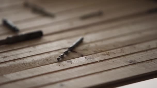 Винты, гвозди и другие металлические инструменты помещаются на деревянный стол на складе . — стоковое видео