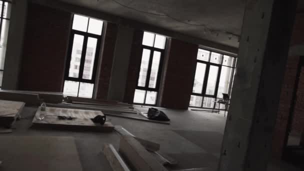 View of apartment with big black framed windows, planks on floor and scaffolding — Stock Video