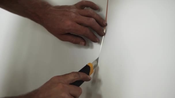 相机显示工人的手用黄色的纸刀切割白纸. — 图库视频影像