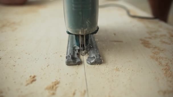 Work flow of green dusty electric jigsaw cutting wooden plank. — Stock Video