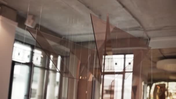 Brun glas installationer hängande med vita snören roterande i ljus hall — Stockvideo