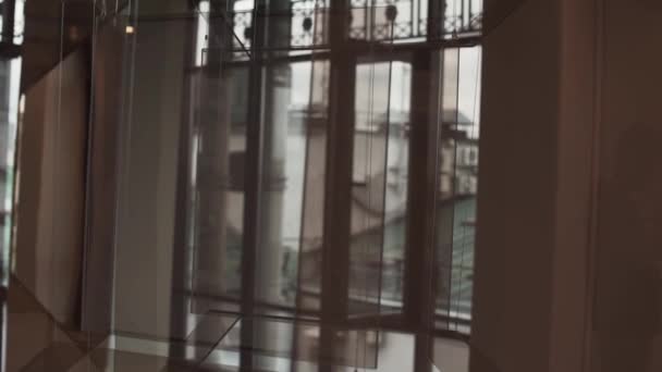 素晴らしい茶色のガラスのインストールが天井からぶら下がっているし 近代美術館ホール ウォーキングの人 壁ふざけてから反射ガラス カメラを移動すると表示されます — ストック動画