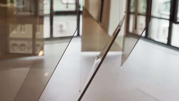 Brown glass installations hanging with white cords are presented at new hall. — Stock Video