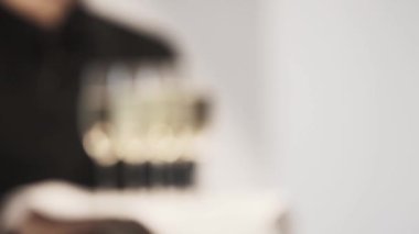 Garson içinde siyah holding tepsi şampanya altı tam gözlük ile bulanık bakış