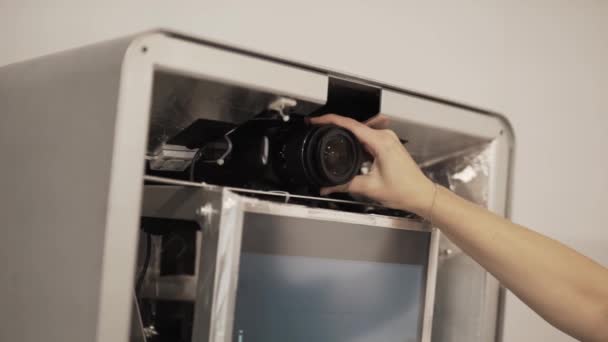 Dames hand instelling lens van zwarte fotocamera geplaatst in de grote doos in de kamer. — Stockvideo