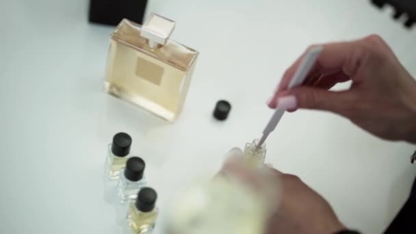 Mãos femininas segurar listras de teste de perfume branco sobre a mesa com amostras . — Vídeo de Stock