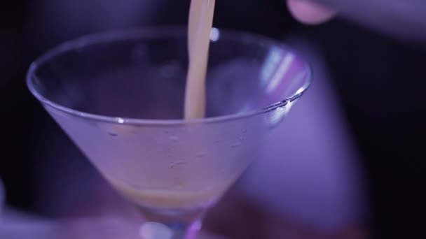 Крупный план стаканов для коктейлей, наполненных жидкостью при тусклом освещении на барном столе . — стоковое видео