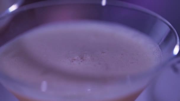 Vista de perto de óculos de coctail cheios de líquido em iluminação escurecida no balcão de bar — Vídeo de Stock