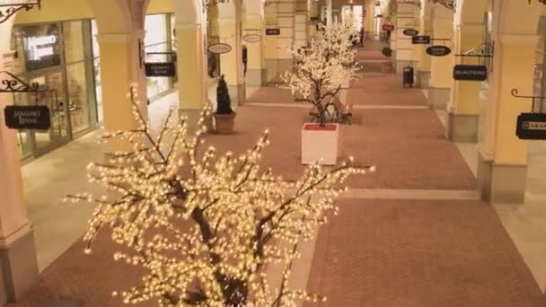 Belle rue lumineuse avec des bâtiments de magasins jaunes éclairés et wa — Video