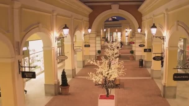 Mooie lichte street met verlichte gele winkel gebouwen en wa — Stockvideo