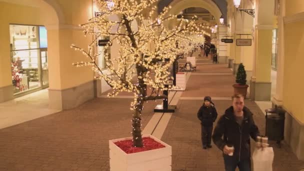 Rue de lumière d'hiver avec des bâtiments de magasins jaunes éclairés et — Video