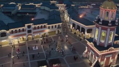Çatı üstleri, mağazaları mağazaları aydınlatma ve yürüyen insanlarla quadcopter görünümü