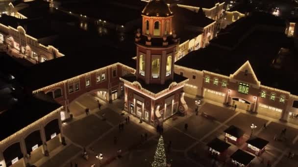 Linda plaza pequeña con pino iluminado con decoraciones en la noche — Vídeos de Stock