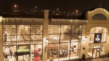 Parlak cam cephe, karanlık çatı üstleri, mağaza binaları ve gece city ile saklamak.